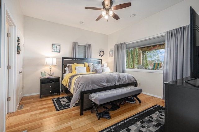 bedroom featuring ceiling fan, light wood-style flooring, and baseboards