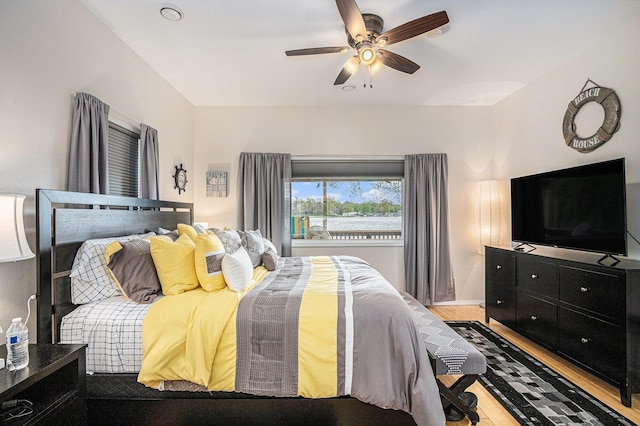 bedroom featuring wood finished floors, baseboards, and ceiling fan