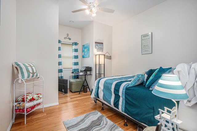 bedroom featuring baseboards, a ceiling fan, and wood finished floors
