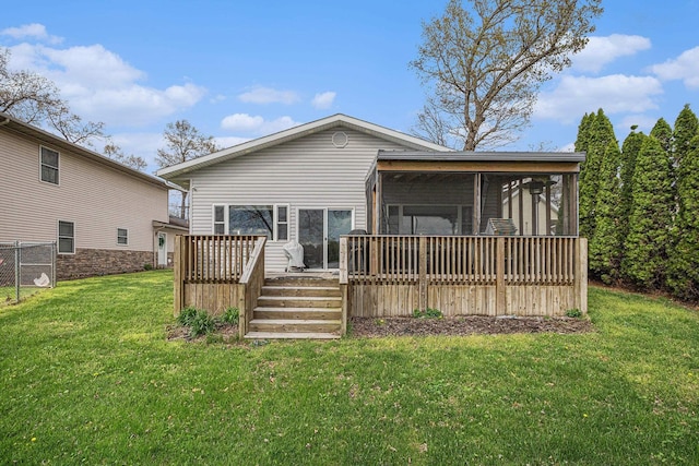 rear view of property with a lawn, a wooden deck, and a sunroom