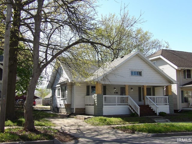 view of front of property featuring covered porch and a shingled roof