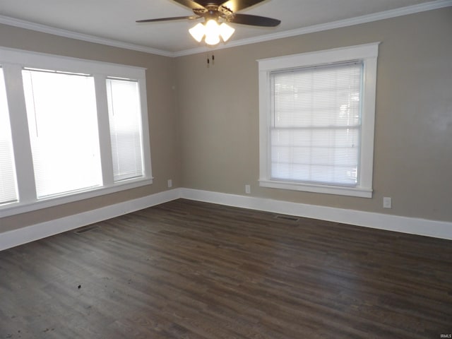empty room featuring baseboards, a healthy amount of sunlight, dark wood finished floors, and crown molding
