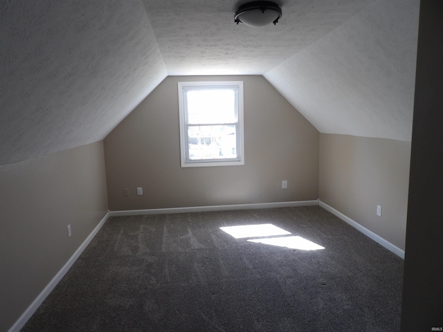 bonus room with carpet, a textured ceiling, vaulted ceiling, and baseboards