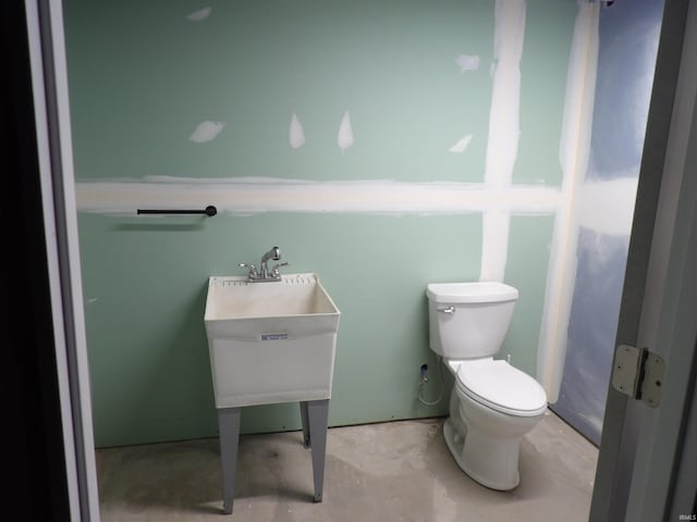 bathroom with toilet and concrete flooring