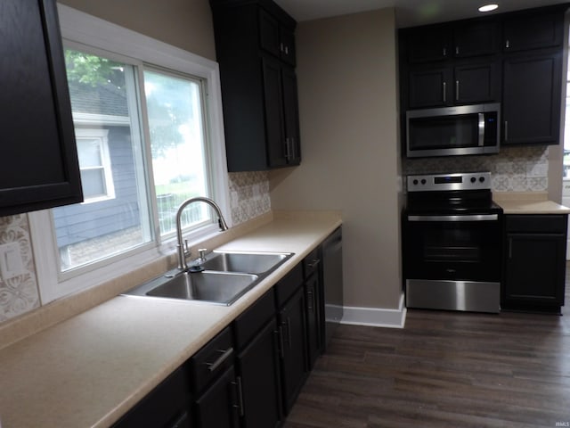 kitchen featuring dark wood finished floors, appliances with stainless steel finishes, plenty of natural light, and a sink