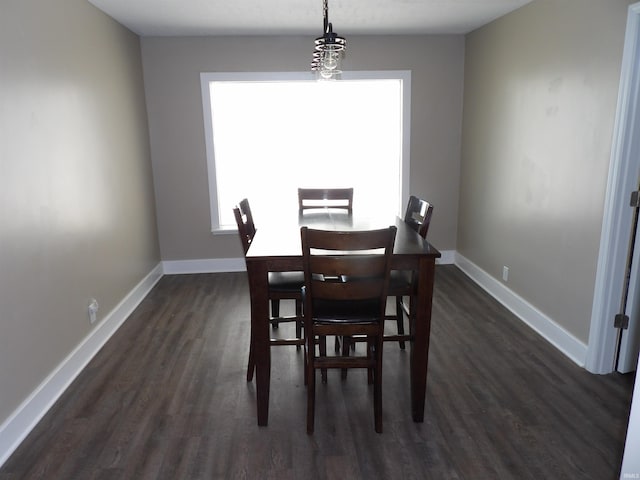 dining space featuring baseboards and dark wood-type flooring
