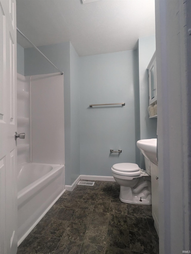 full bathroom featuring stone finish floor, toilet, baseboards, visible vents, and tub / shower combination