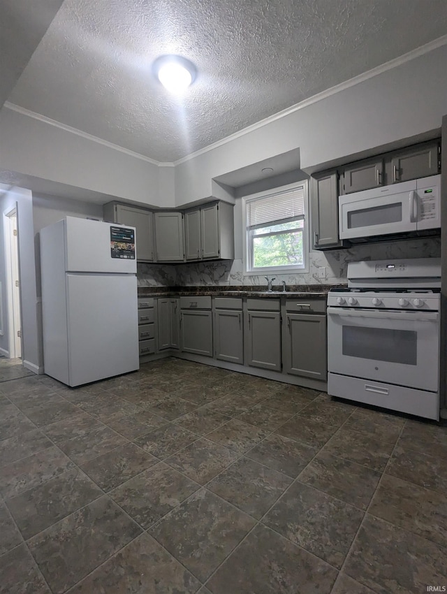 kitchen with dark countertops, a textured ceiling, gray cabinetry, and white appliances