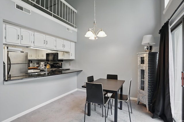 9404 S Lake Ridge Dr, Bloomington, IN 47401 - dining space with light colored carpet, a towering ceiling, baseboards, and visible vents