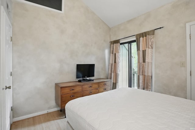 9404 S Lake Ridge Dr, Bloomington, IN 47401 - bedroom with lofted ceiling, baseboards, and light wood-type flooring