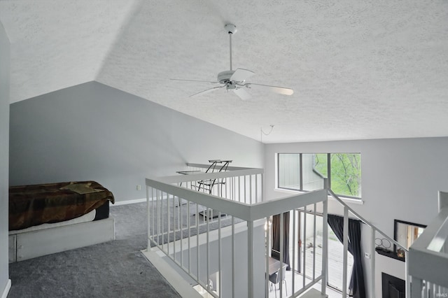 9404 S Lake Ridge Dr, Bloomington, IN 47401 - stairway with a ceiling fan, a textured ceiling, baseboards, carpet flooring, and vaulted ceiling