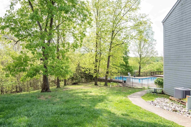 view of yard featuring cooling unit and a fenced in pool