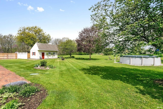 view of yard featuring fence and an outdoor pool