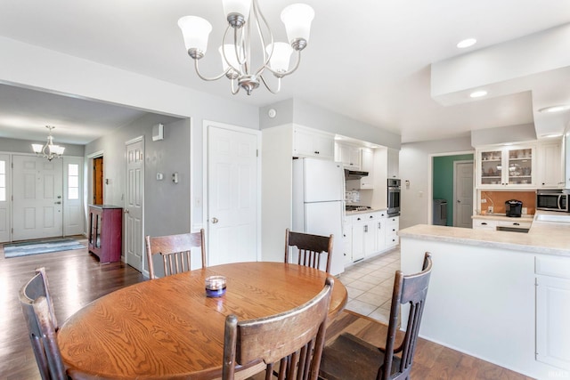 dining room with wood finished floors, a notable chandelier, and recessed lighting