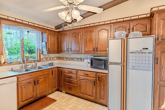 kitchen featuring lofted ceiling, white appliances, a sink, brown cabinets, and light countertops