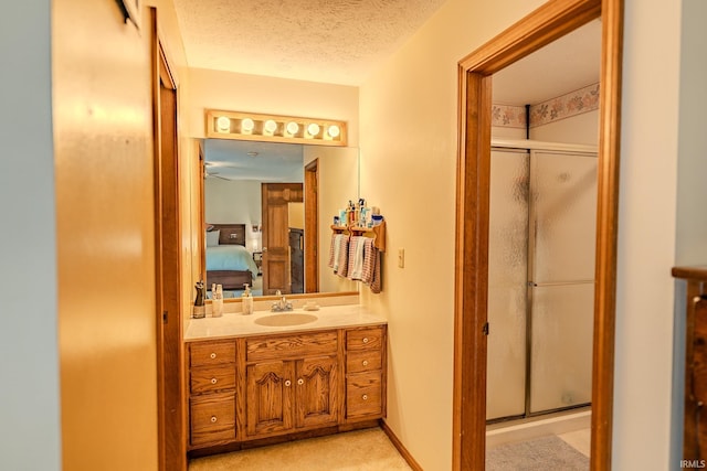 ensuite bathroom with a stall shower, ensuite bathroom, vanity, and a textured ceiling