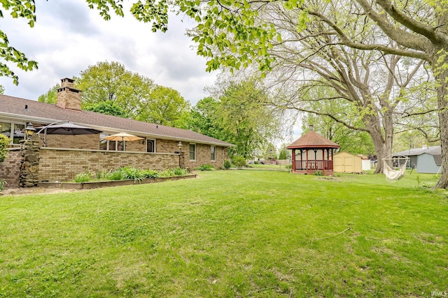 view of yard with an outbuilding, a gazebo, and a shed
