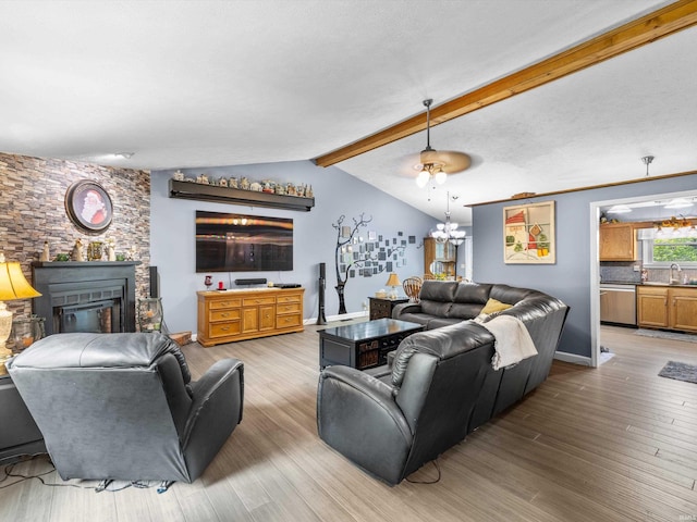living area with a large fireplace, an inviting chandelier, wood finished floors, and lofted ceiling with beams