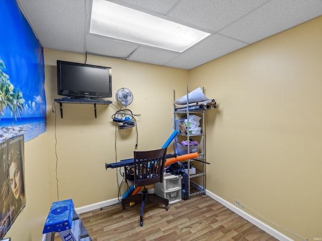game room with a drop ceiling, wood finished floors, and baseboards