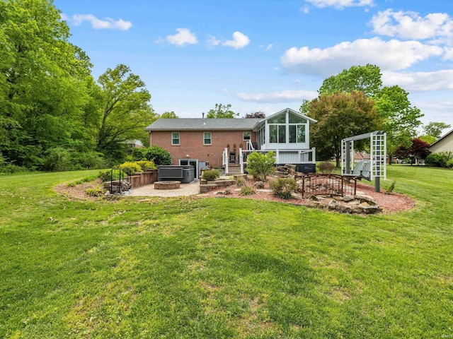 back of house with an outdoor fire pit, a patio area, a sunroom, and a lawn