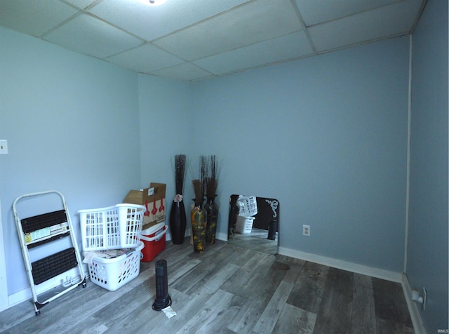 miscellaneous room featuring a paneled ceiling, baseboards, and wood finished floors