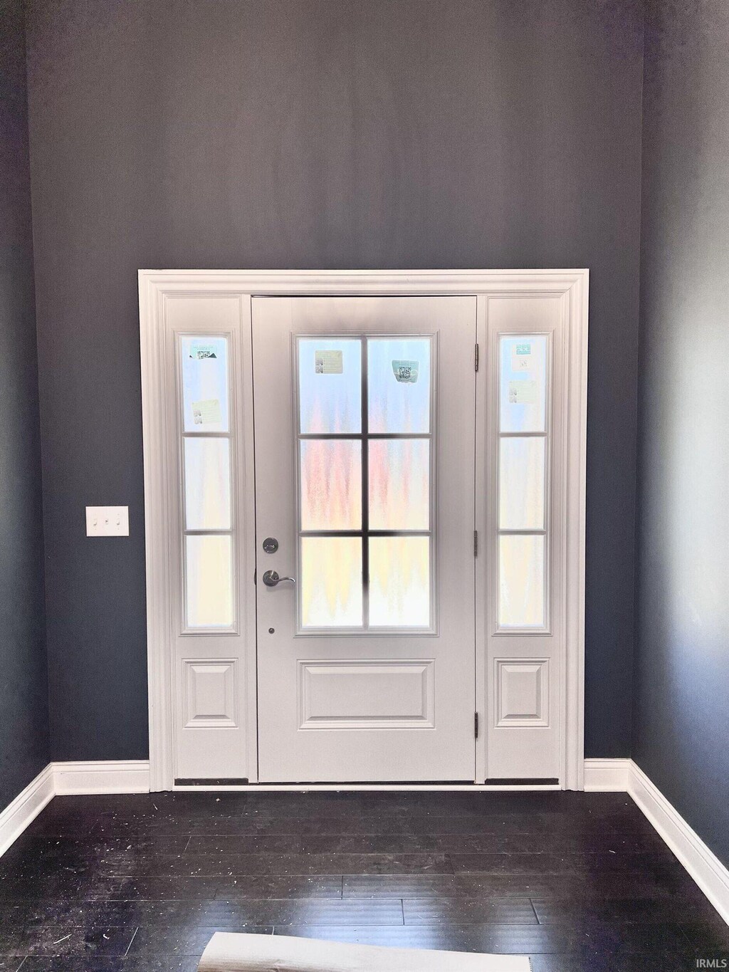 doorway to outside with baseboards and wood-type flooring