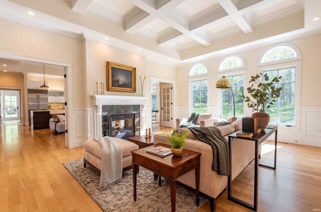 9225 S Foggy Ridge Ln, Bloomington, IN 47401 - living area with a fireplace, a healthy amount of sunlight, crown molding, a decorative wall, and beamed ceiling