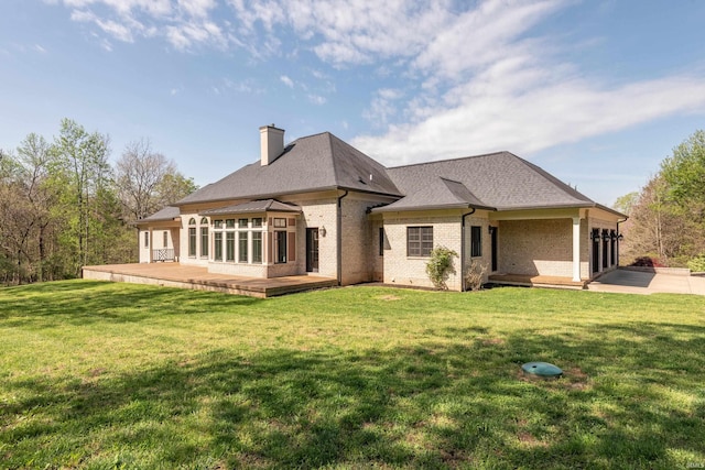 9225 S Foggy Ridge Ln, Bloomington, IN 47401 - rear view of property with a chimney, a lawn, a wooden deck, a shingled roof, and brick siding