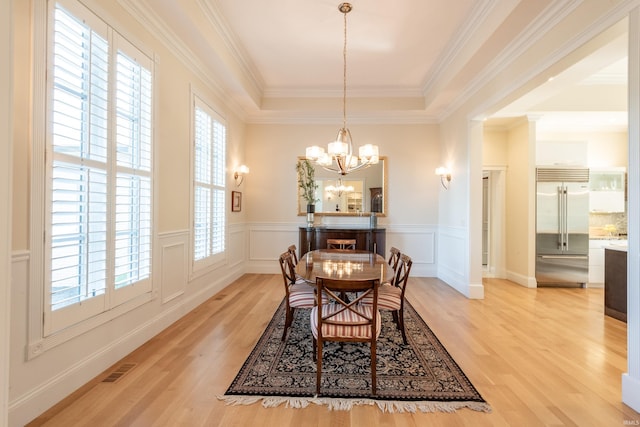 9225 S Foggy Ridge Ln, Bloomington, IN 47401 - dining room featuring a chandelier, crown molding, a wainscoted wall, a raised ceiling, and light wood-style floors
