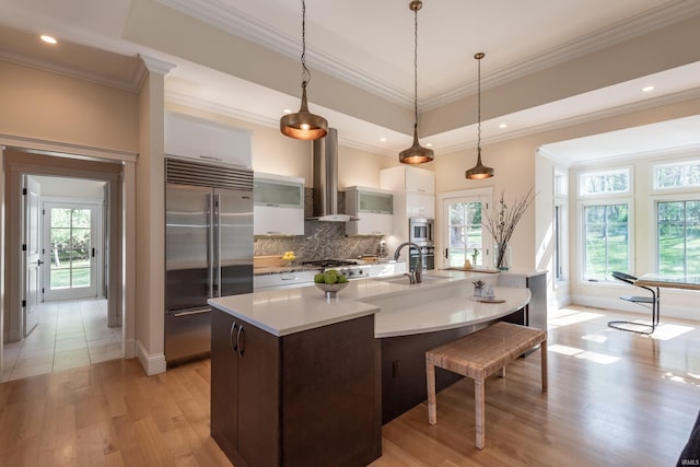 9225 S Foggy Ridge Ln, Bloomington, IN 47401 - kitchen with stainless steel appliances, ventilation hood, decorative backsplash, light countertops, and light wood-type flooring