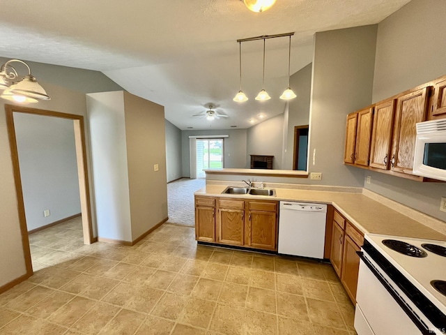 kitchen featuring decorative light fixtures, brown cabinetry, white appliances, a sink, and vaulted ceiling