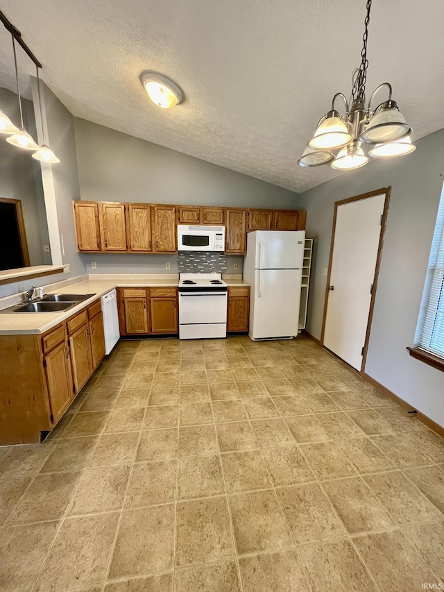 kitchen with brown cabinets, a sink, white appliances, light countertops, and lofted ceiling