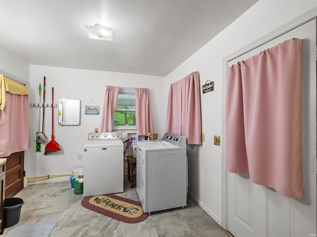 laundry area with baseboards, separate washer and dryer, and laundry area