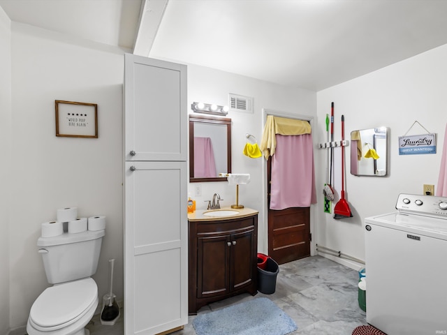 bathroom featuring toilet, visible vents, baseboards, vanity, and washer / clothes dryer