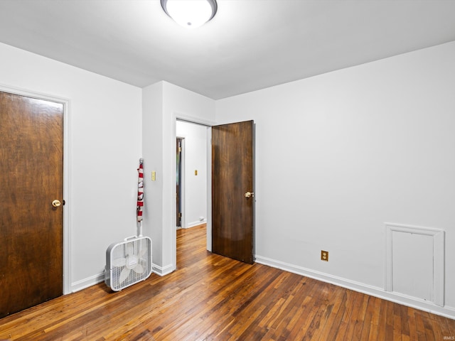 unfurnished bedroom with baseboards and wood-type flooring