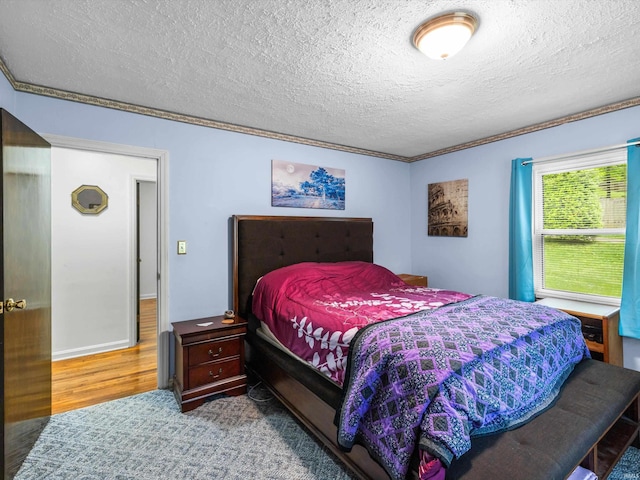 bedroom with a textured ceiling, wood finished floors, and ornamental molding