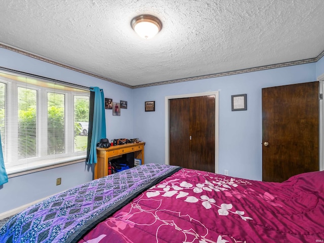 bedroom with crown molding, a textured ceiling, and a closet