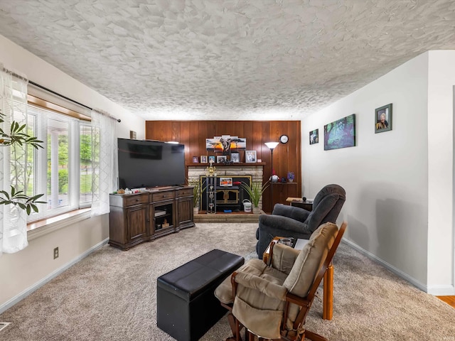 living area with light carpet, wood walls, a brick fireplace, and baseboards