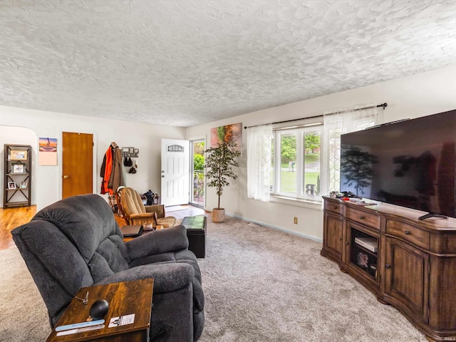 living area with light colored carpet and a textured ceiling
