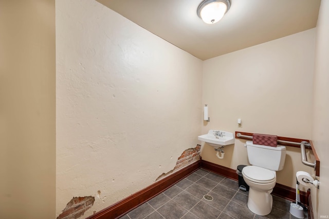 bathroom featuring toilet, tile patterned flooring, and baseboards