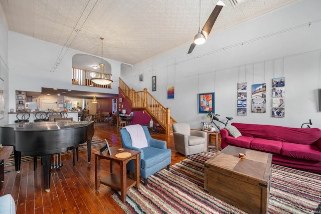living room featuring stairway, a towering ceiling, and hardwood / wood-style flooring