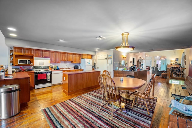 dining area with light wood-style flooring, visible vents, and recessed lighting