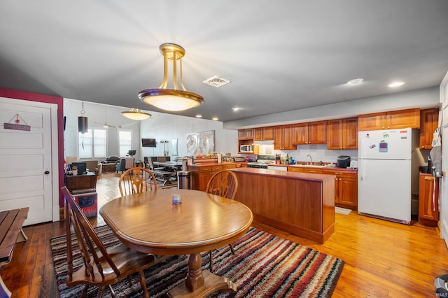 dining space with light wood finished floors, visible vents, and recessed lighting