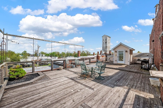 deck with outdoor dining space and grilling area