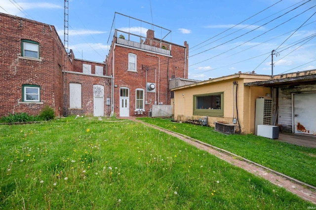 back of house with a yard and central air condition unit