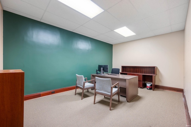 office space with a paneled ceiling, carpet, and baseboards