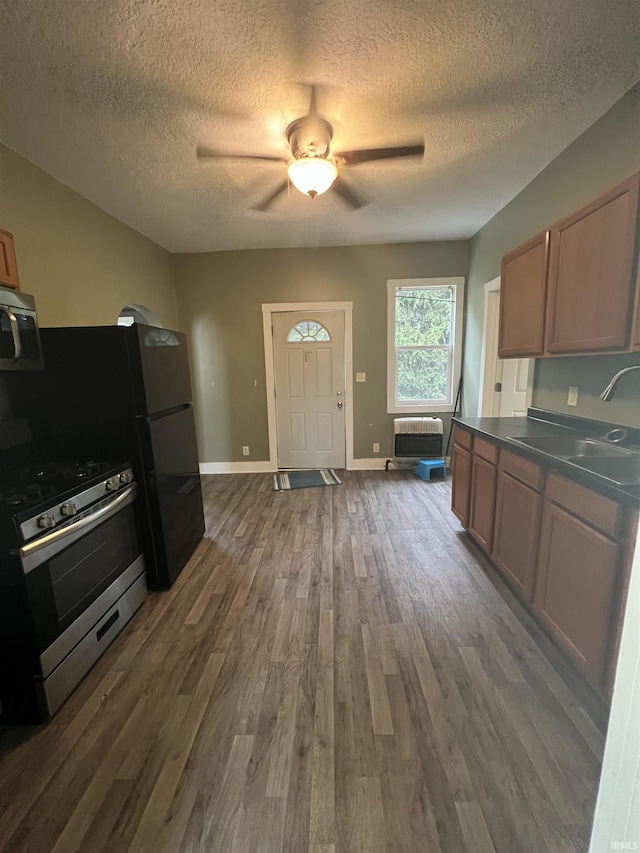 712 E Water St, Portland, IN 47371 - kitchen with a sink, stainless steel appliances, a textured ceiling, and dark wood-type flooring