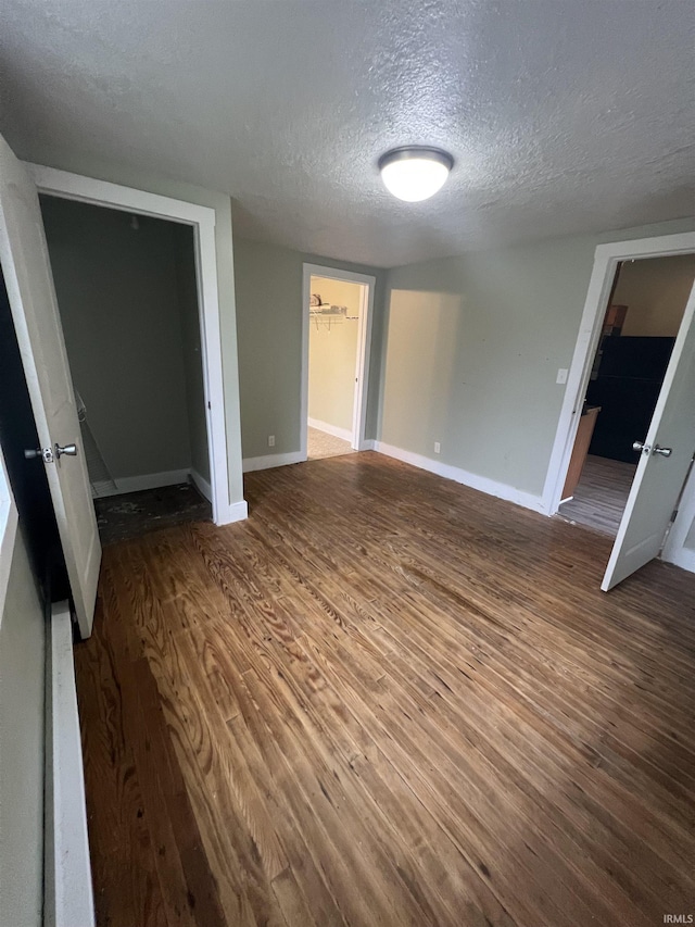 712 E Water St, Portland, IN 47371 - unfurnished bedroom featuring baseboards, a textured ceiling, and wood finished floors