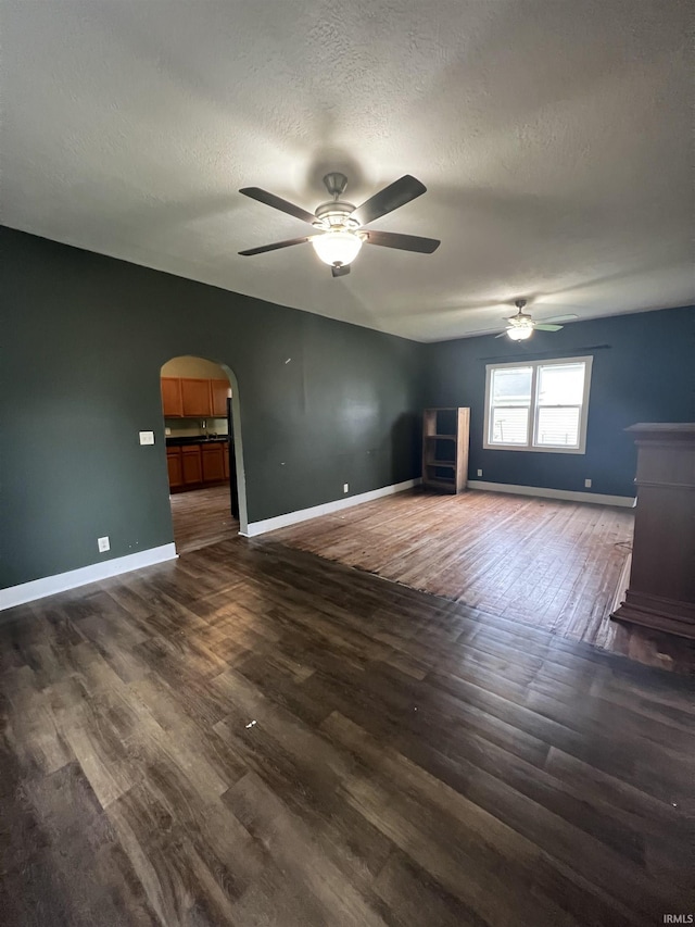 712 E Water St, Portland, IN 47371 - spare room featuring a textured ceiling, baseboards, a ceiling fan, and dark wood-type flooring
