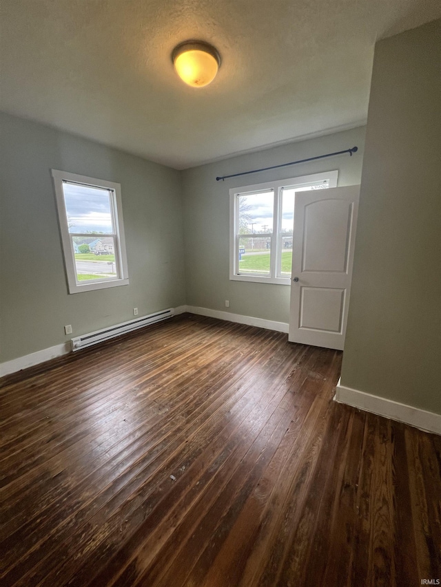 712 E Water St, Portland, IN 47371 - empty room featuring dark wood-type flooring, baseboards, and a baseboard radiator